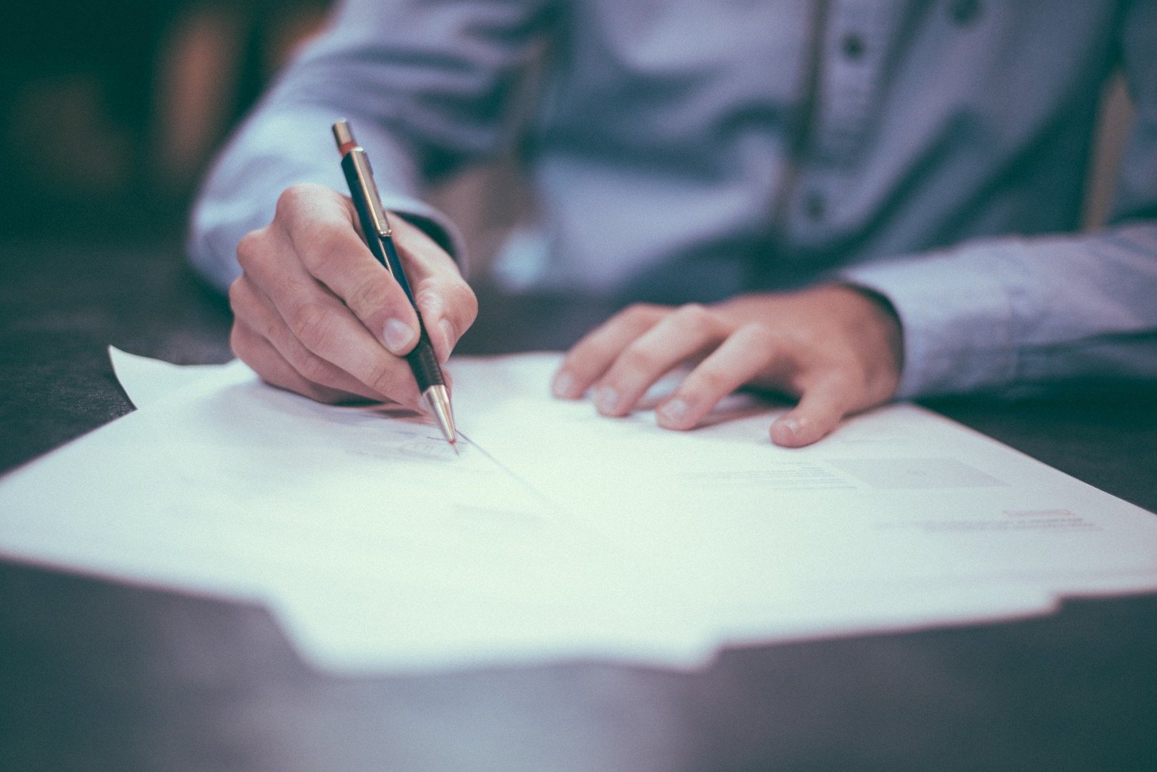 A close-up of a man signing a document