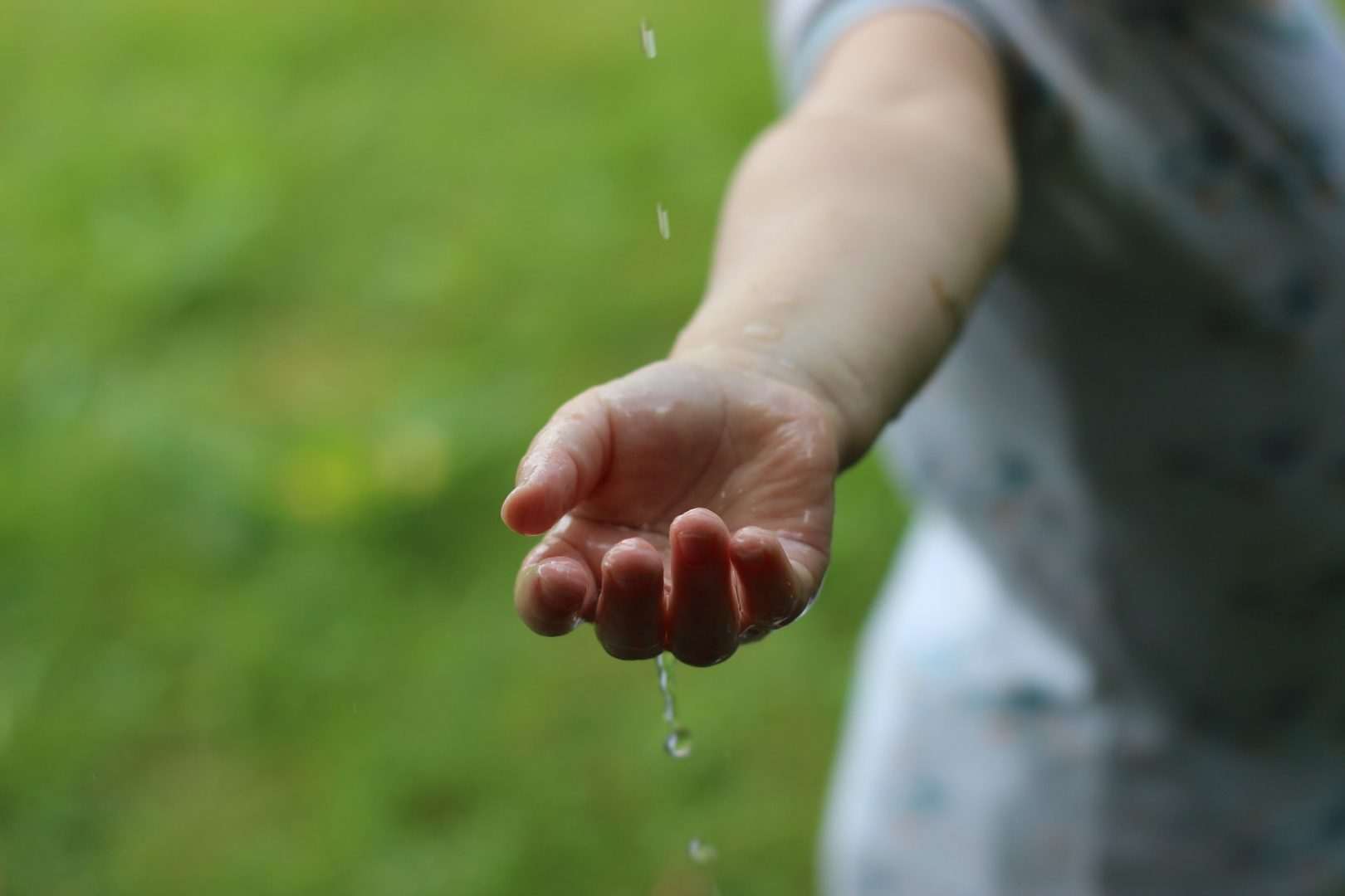 Rain falling on a child's hand