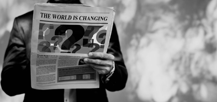 Man reading a newspaper with the title - The world is changing