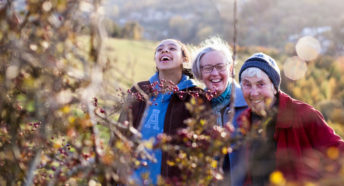 Women looking at a red berry hedge on a walk in the countryside