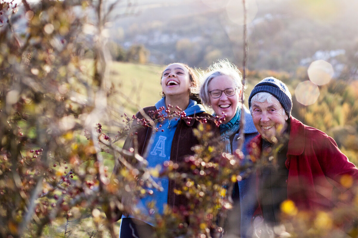 Women looking at a red berry hedge on a walk in the countryside