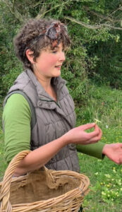 Katy Fullilove holding an edible flower and talking about it.