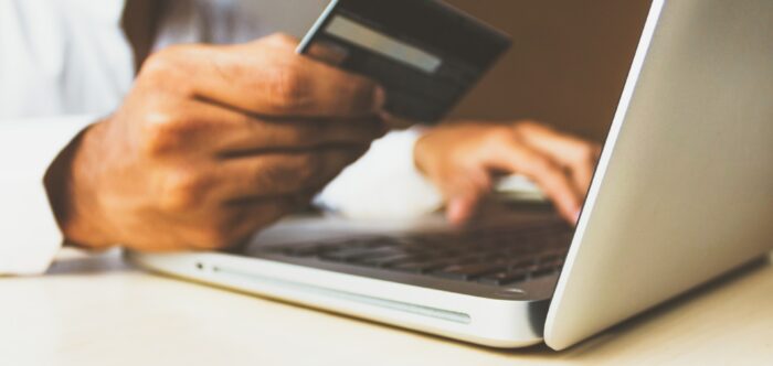 A man making an online payment using a credit card and laptop