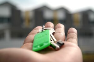 A hand holding a key to a new house
