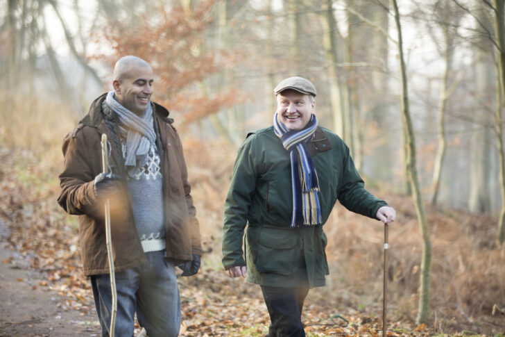 Two men walking in the woods in Autumn
