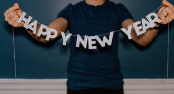 A person holding a banner saying "Happy New Year"