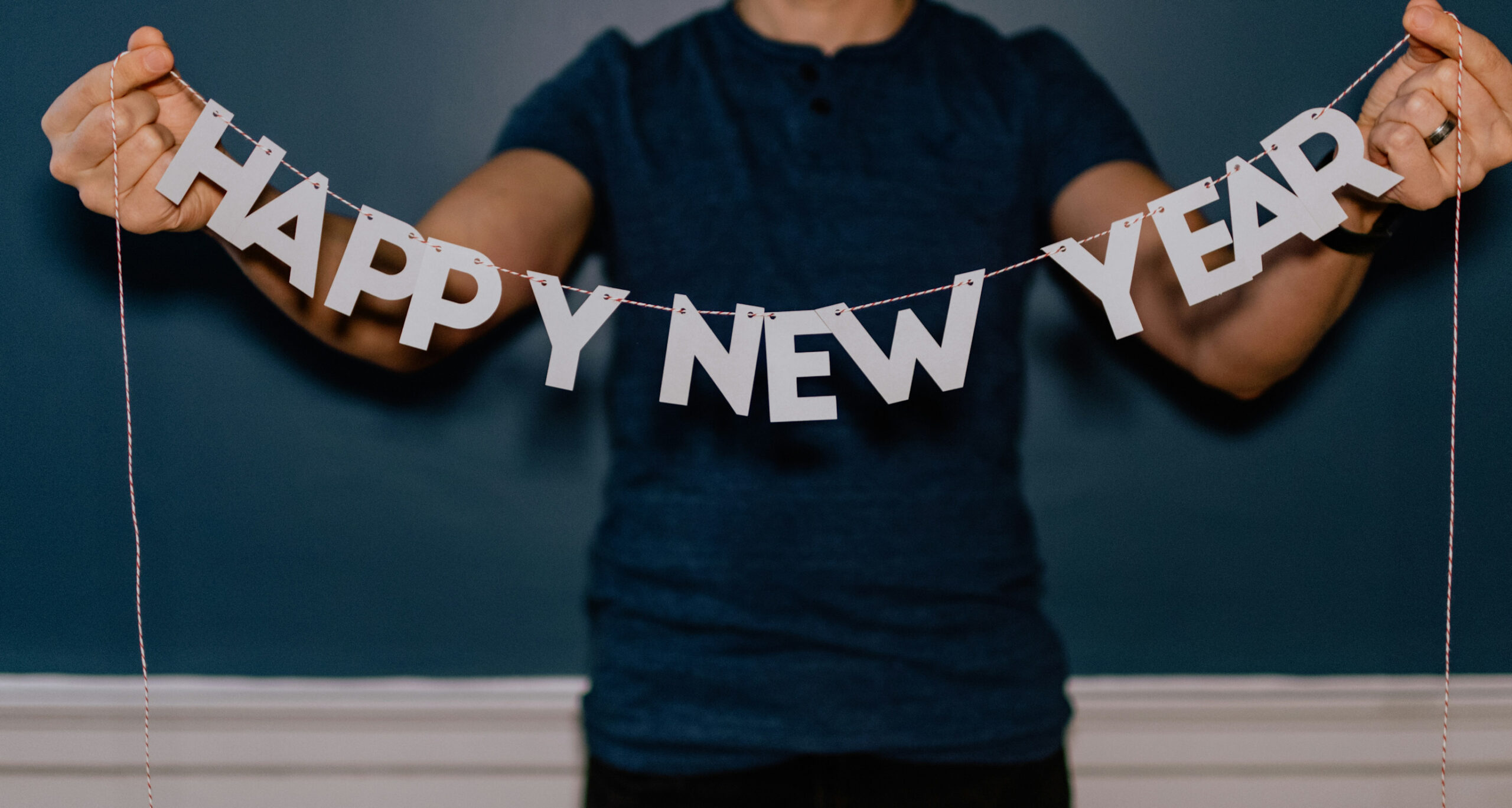 A person holding a banner saying "Happy New Year"