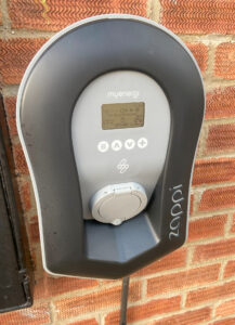 A Zappi electric car charger located on the side of a house