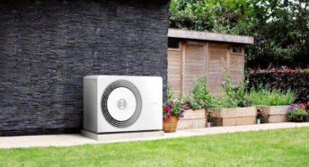 An air source heat pump located on an external wall in a garden