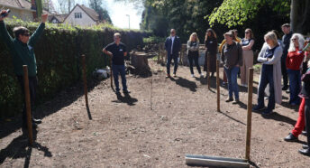 A group of people stand in nature listening to Daniel Salliss (BFL) giving a presentation on biodiversity