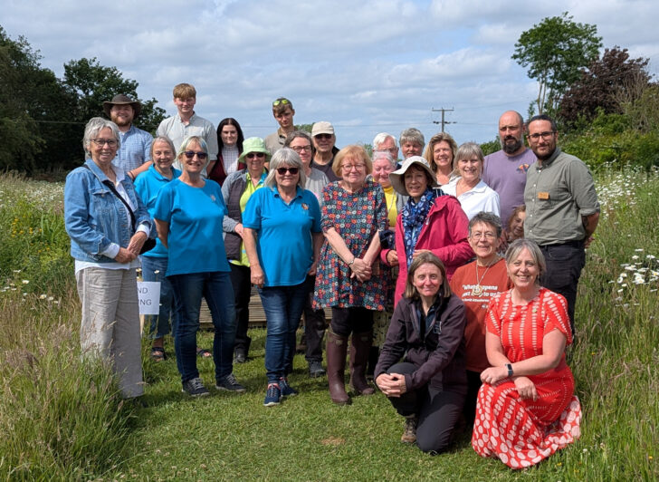 A large group of people including stallholders and volunteers at the Martha's Meadow event