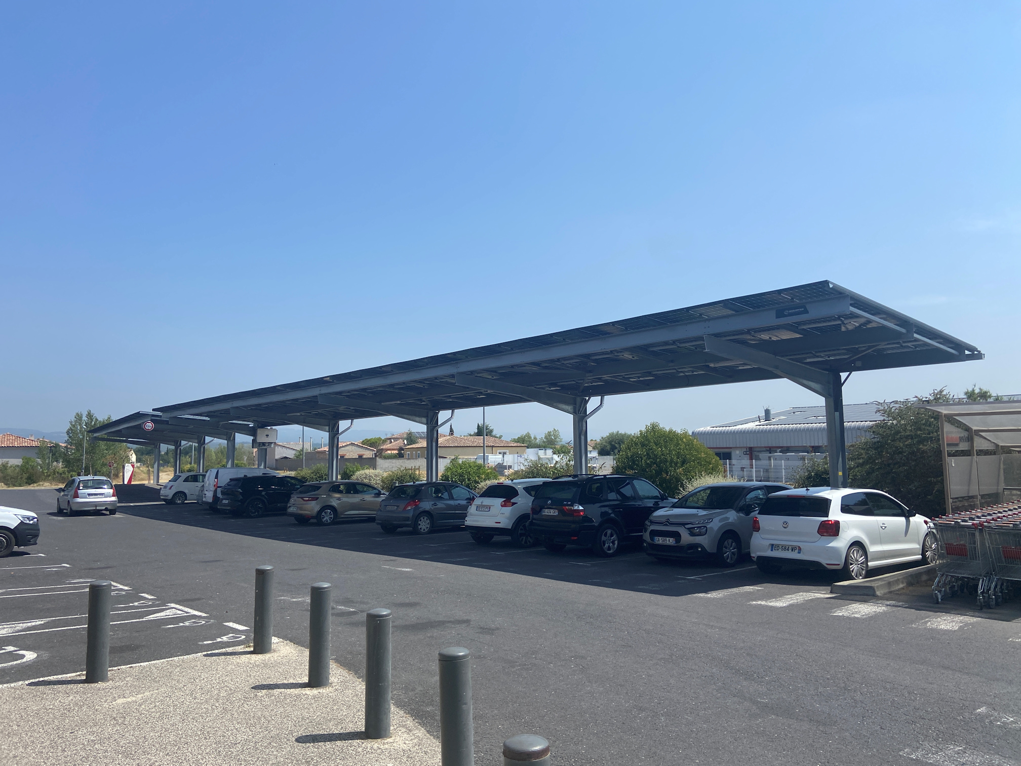Solar panels mounted above the car park spaces at a supermarket in Alzonne, France