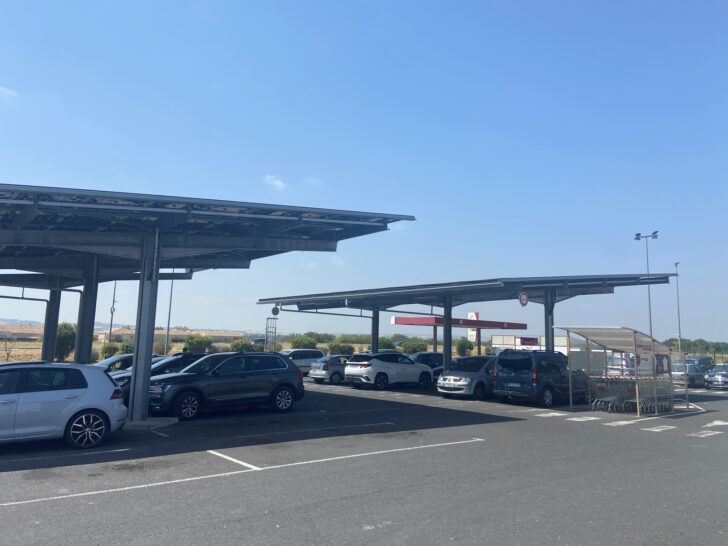 Solar panels mounted above the car park spaces at a supermarket in Alzonne, France