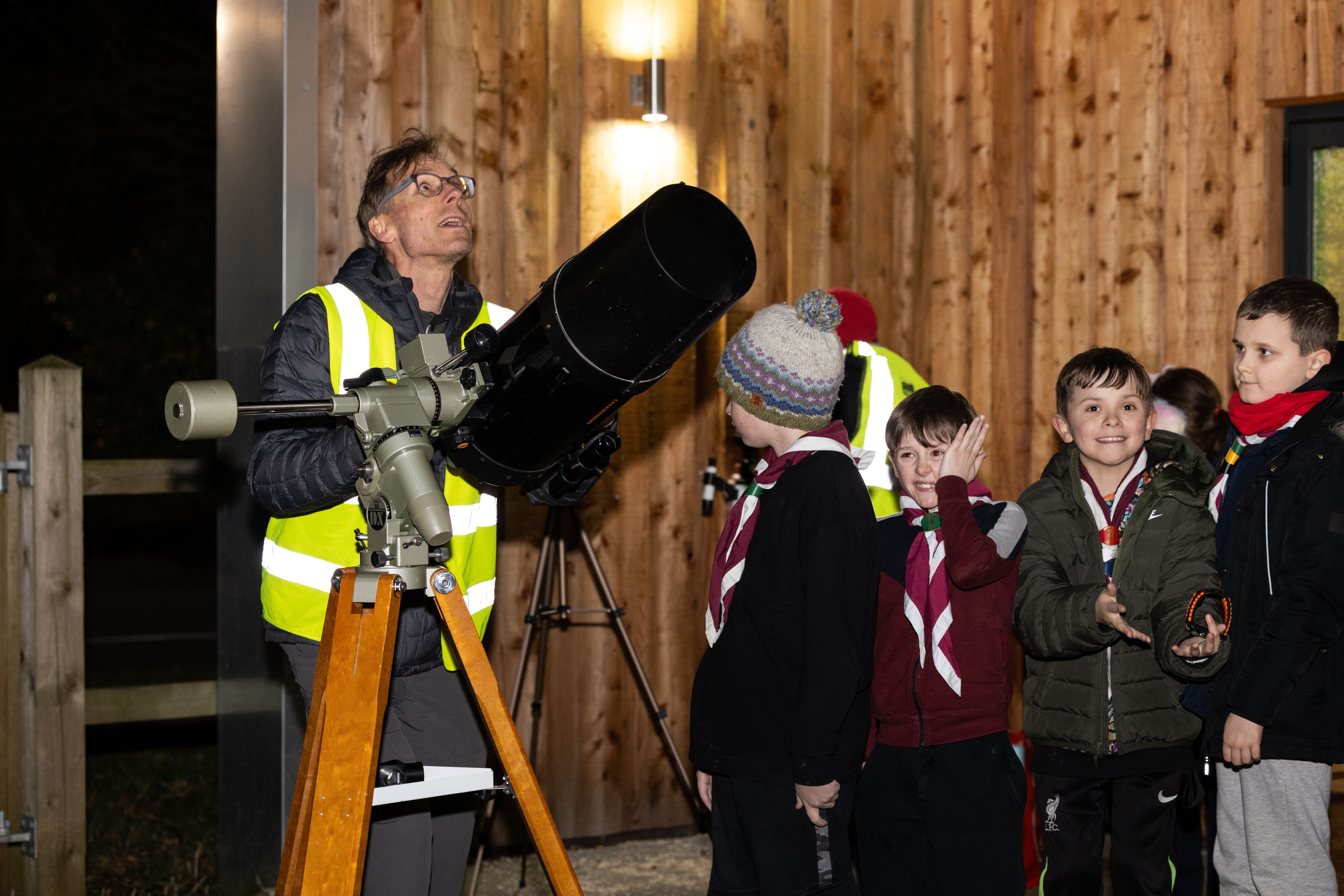 A group of children queuing up to look through a telescope